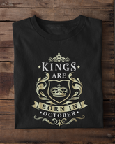 Black t-shirt with 'Kings are born in October' design on a wooden surface.